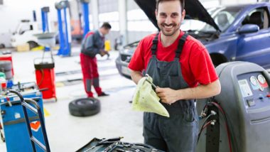 Zdjęcie przedstawia mechanika samochodowego pracującego w centrum serwisowym samochodów